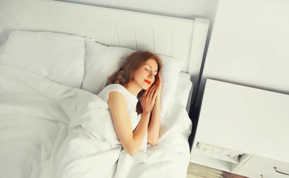 Young woman sleeping on the bed on soft pillows 