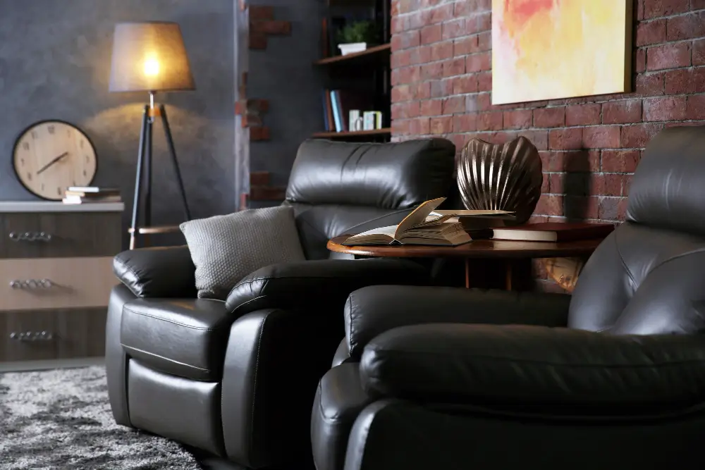 A cozy living room featuring a black leather recliner and a stylish coffee table, creating a welcoming atmosphere.