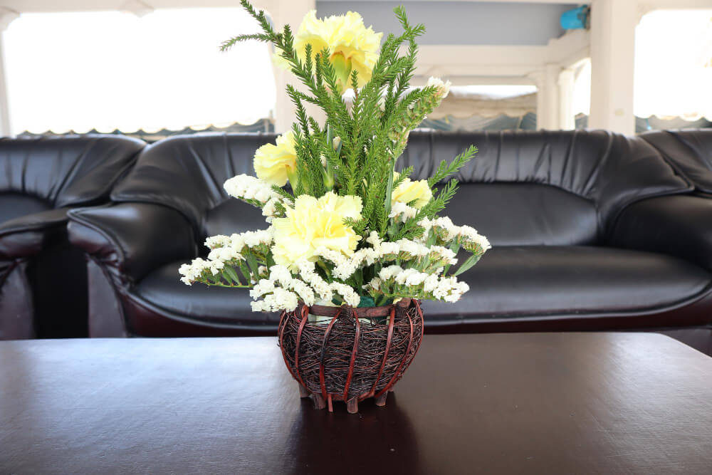 A vase filled with colorful flowers sits elegantly on a wooden table, adding charm to the room's decor.