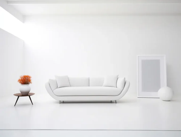 A bright white living room featuring a comfortable sofa and a decorative vase on a table.